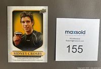 Front of the Sidney Crosby hockey card showing the player holding a hockey puck against a gold and black background with the Tim Hortons branding.