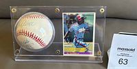 View of the autographed baseball and the signed 1984 Fleer Al Oliver card displayed side by side in the clear Lucite case.