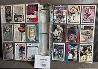 Photo of multiple hockey cards in binder pages, showing both front and back of some cards from various NHL teams and years 1990-91 to 1996-97.