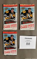 Front view of three unopened Tim Hortons 2016-17 hockey card packs featuring a Penguins player on the packaging.