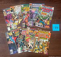 Full spread of all 10 Marvel comic books laid out on floor with blue lot number card