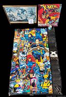 Photo showing the three items included in the lot: a 1994 X-Men poster calendar laid flat, the 1998 Wolverine Files calendar standing, and the framed print in a box.
