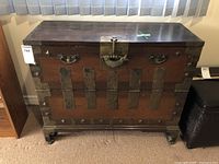 Front view of rectangular Chinese wood storage cabinet with brass hardware