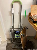 Full view of the folded Cosco hand cart with wheels on the side and base platform.