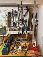 Overview of hand tools arranged on a workbench including saws, clamps, screwdrivers, levels and paintbrushes.