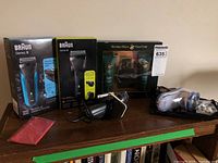 Five items arranged on table: two boxed Braun Series 3 electric shavers, two used electric shavers, and Polo Club after shave set in box.