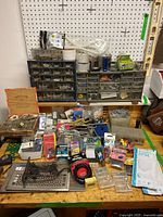 Overview of the workbench with multiple hardware items and storage cabinets containing screws and fasteners.