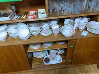 Overview of china set arranged on wooden shelf