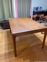 Overall view of rectangular teak table without leaves