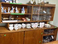 Full view of assembled teak sideboard with hutch loaded with dishes