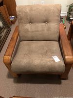 Front view of teak framed armchair with both cushions in place on carpeted floor.