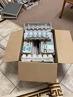 Box filled with multiple cardboard egg cartons each containing used golf balls.