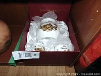 White porcelain 50th anniversary tea set (teapot, creamer, sugar) in red box with white satin lining, gold floral decoration.