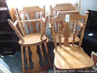 Six oak chairs, 2 captain chairs with armrests and 4 regular chairs, all with turned legs and carved backs.