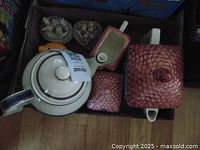 Photo showing a white ceramic teapot, pink floral creamer and sugar bowl, and several trinket boxes.