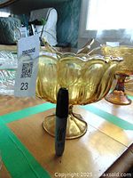 Vintage amber glass footed fruit bowl shown upright beside a Sharpie marker to indicate size. The bowl has a scalloped rim and pedestal base.