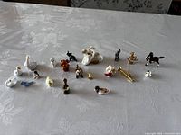 Full view of all tiny animal figurines arranged on a white tablecloth.