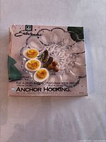 Boxed Anchor Hocking clear glass egg plate with sample devilled eggs on the packaging showing product use.