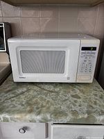 Closed front view of the white Goldstar microwave showing the control panel with digital display and buttons.