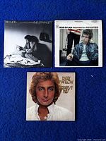 Three album covers - Billy Joel The Stranger, Bob Dylan Highway 61 Revisited, Barry Manilow Greatest Hits