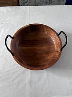 Wooden bowl with black metal handles, showing height and handles design.