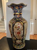 Full view of the antique Asian floor urn showing overall floral and bird designs and scalloped rim.