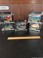 Five Ertl 1:43 scale classic vehicle diecast models in original packaging, showing front and side views of boxes