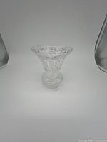 Single clear crystal vase with hand-cut pattern and footed base shown from front.