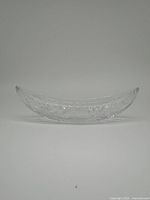 Side profile of the Imperial oval glass relish bowl, showing the curved sawtooth edges and smooth clear glass body.