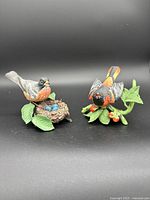 Front view of two colorful Lenox bird figurines: American Robin with nest and eggs, Baltimore Oriole on leaves