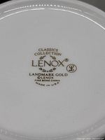 Bottom of a Lenox mug showing manufacturer markings: Classics Collection, Landmark Gold, Lenox, Fine Bone China, Made in USA.