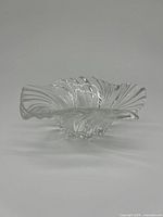 Front/side angle view of the clear crystal bowl showing the swirl pattern and the bowl's shape.