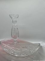Photo of matching crystal relish bowl and vase against plain background.
