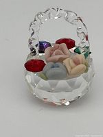 Close-up photo of Swarovski crystal miniature basket filled with detailed porcelain flowers and crystal accents.