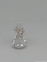 Front view of the miniature bride figurine showing clear crystal body and pink accents on bouquet and dress edges.