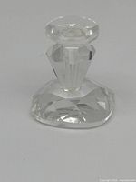 Single clear Swarovski miniature crystal candlestick approx 0.75 inches tall on a plain background.