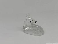Clear Swarovski crystal miniature deer figurine photographed from front angle showing detailed faceted cuts and black eyes and nose.