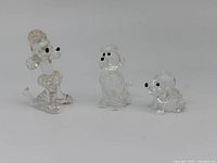 Three Swarovski crystal miniature poodles positioned side by side, seen from the front