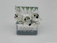 Front view of Swarovski clear crystal miniature toy box with ‘TOYS’ written and animal figurines attached or placed behind, showing dog, bear, and rabbit.