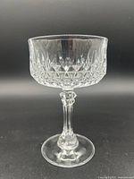 Single vintage Cristal D'Arques crystal champagne glass displayed upright showing detailed cut-glass pattern and stem