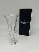 Front view of the 9 inch Waterford Crystal Lismore footed vase and original box showing diamond and wedge cuts and green label on foot.