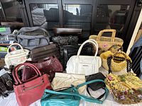 Overview of assorted handbags and purses showing variety of colors and styles.