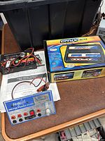 Onyx X380 Charger box, HobbiCo Deluxe Power Panel, instruction paperwork, and wiring harness on table.