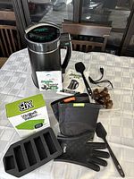 Full view of the Infuzium 420 herbal infuser and included accessories on a table: silicone glove, spatula, butter mold, tincture bottles, thermometer, and manuals.