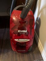 Front view of the red Kenmore Elegance vacuum showing the HEPA filter system and dust container.