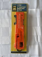 Full packaged view of the orange Power Fist laser level, showing branding and size details.