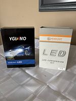 Two boxes of LED car headlight conversion kits standing upright on a white surface.