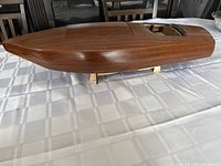 Three-quarter front view of mahogany hull on stand