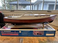 Side view of half-built Cranberry Isle Lobster Yacht hull on original box and stand on workbench