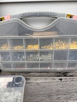 Large plastic organizer showing compartments filled with brass inserts, screws, and terminal connectors